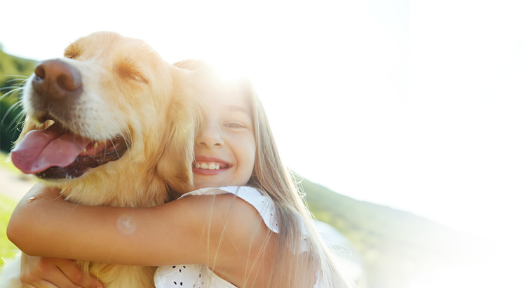 A young girl holding a dog